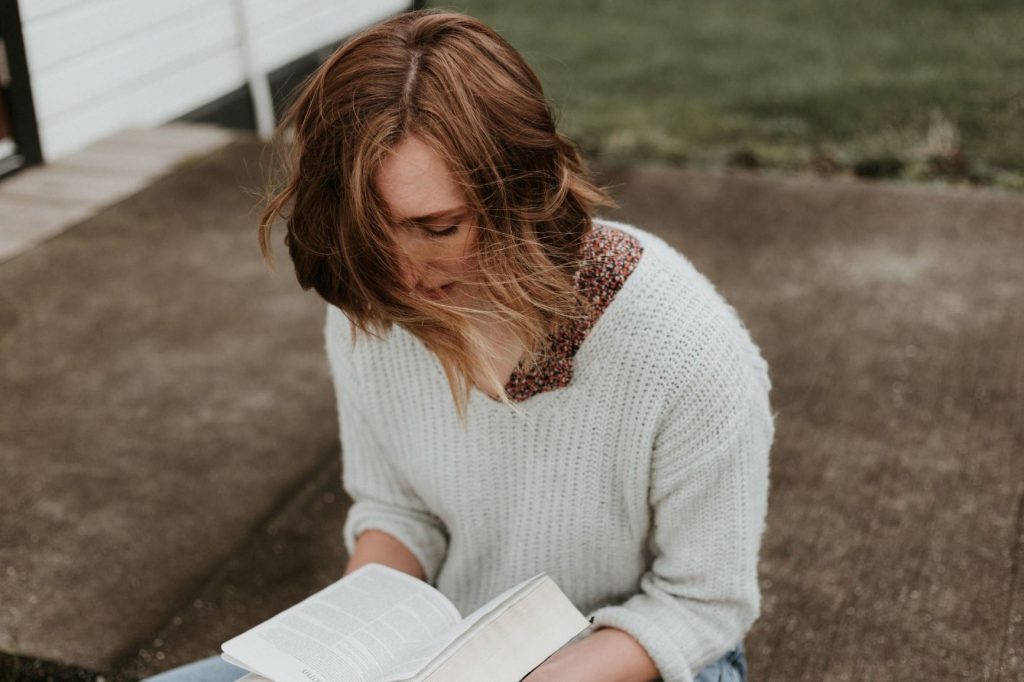 Image of girl reading book outside: 13 New Fiction Releases for Character-Driven Readers