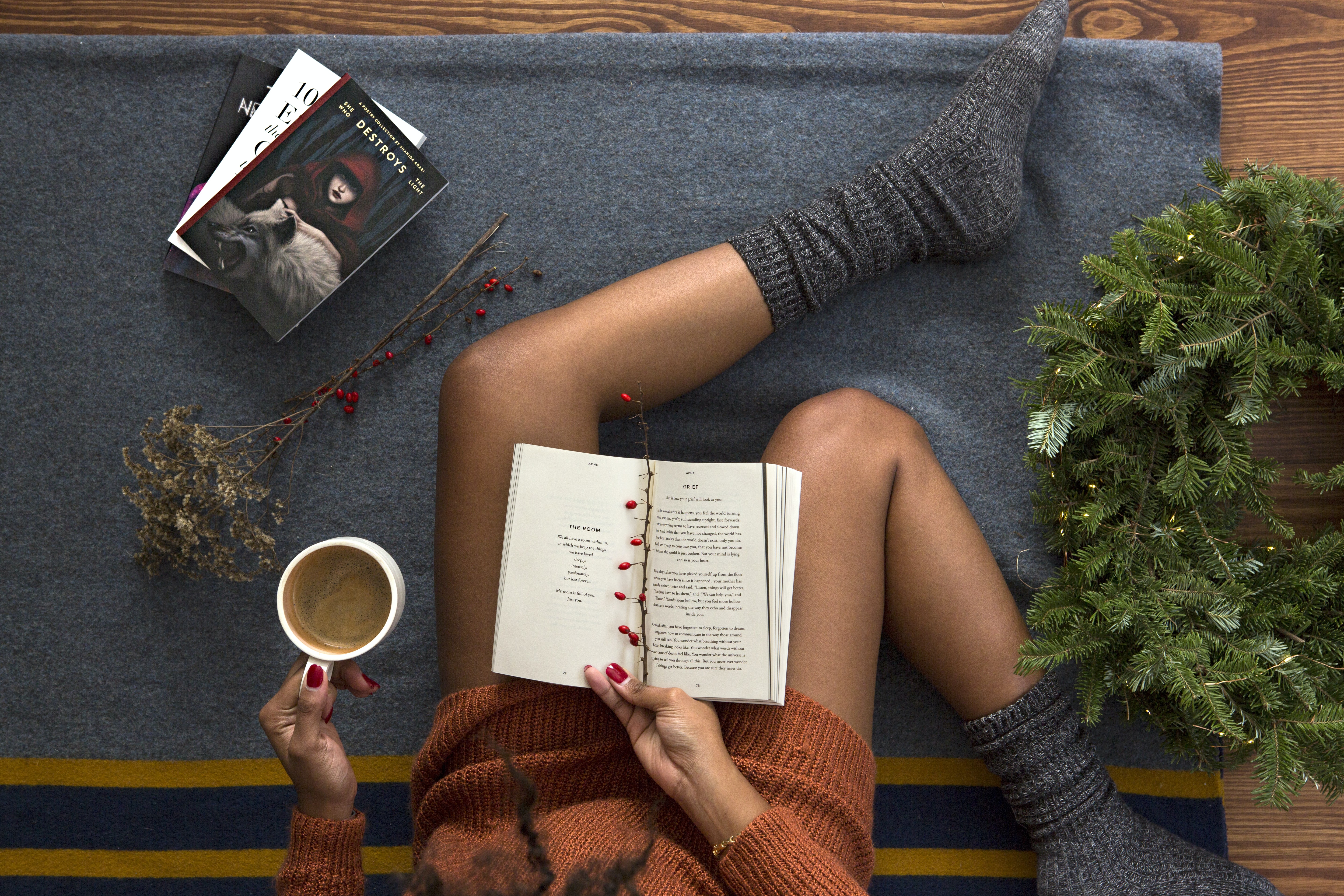 opened book on person's lap with gray socks - christmas-themed novels