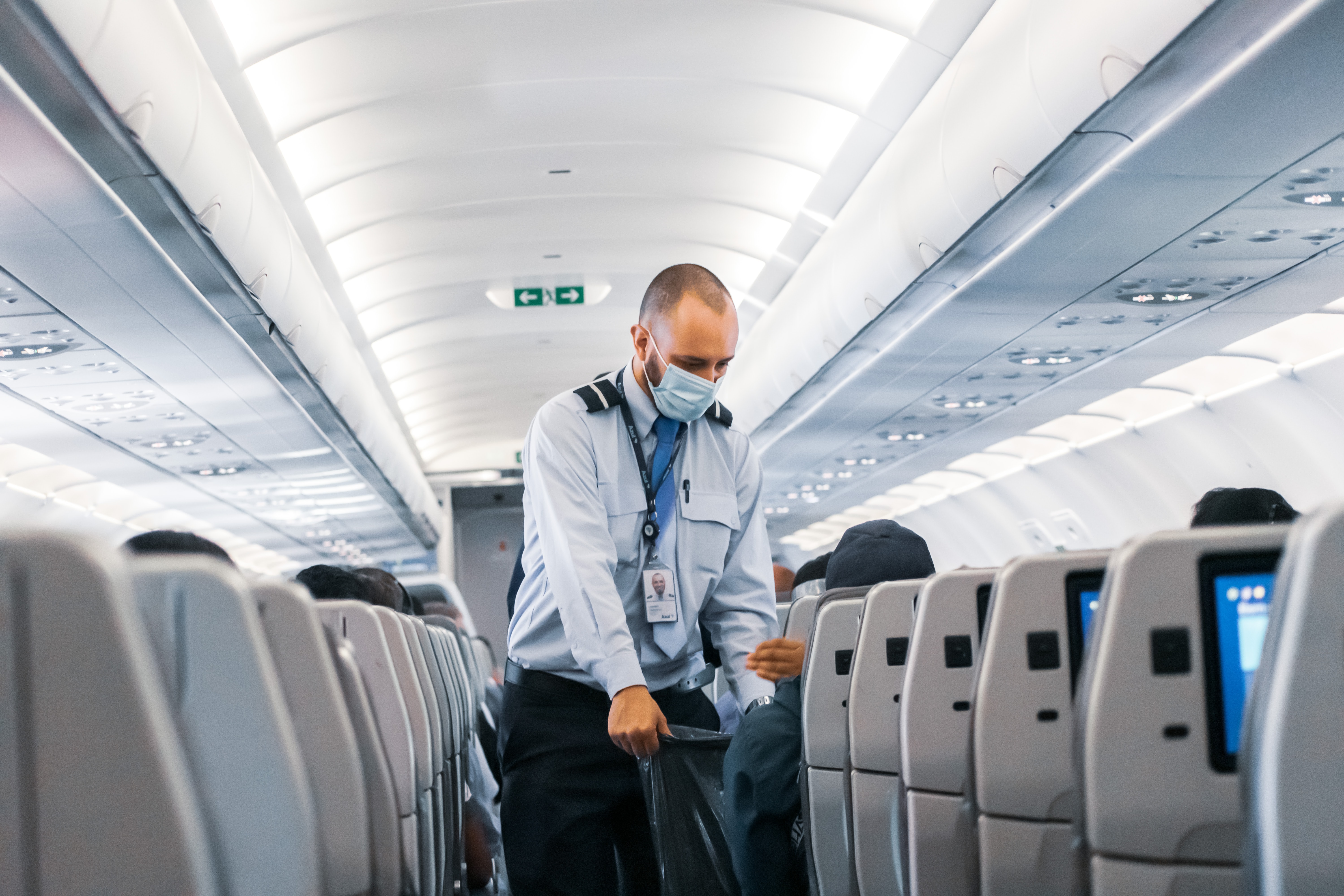 man in blue dress shirt standing in airplane - Back To In-Class Learning