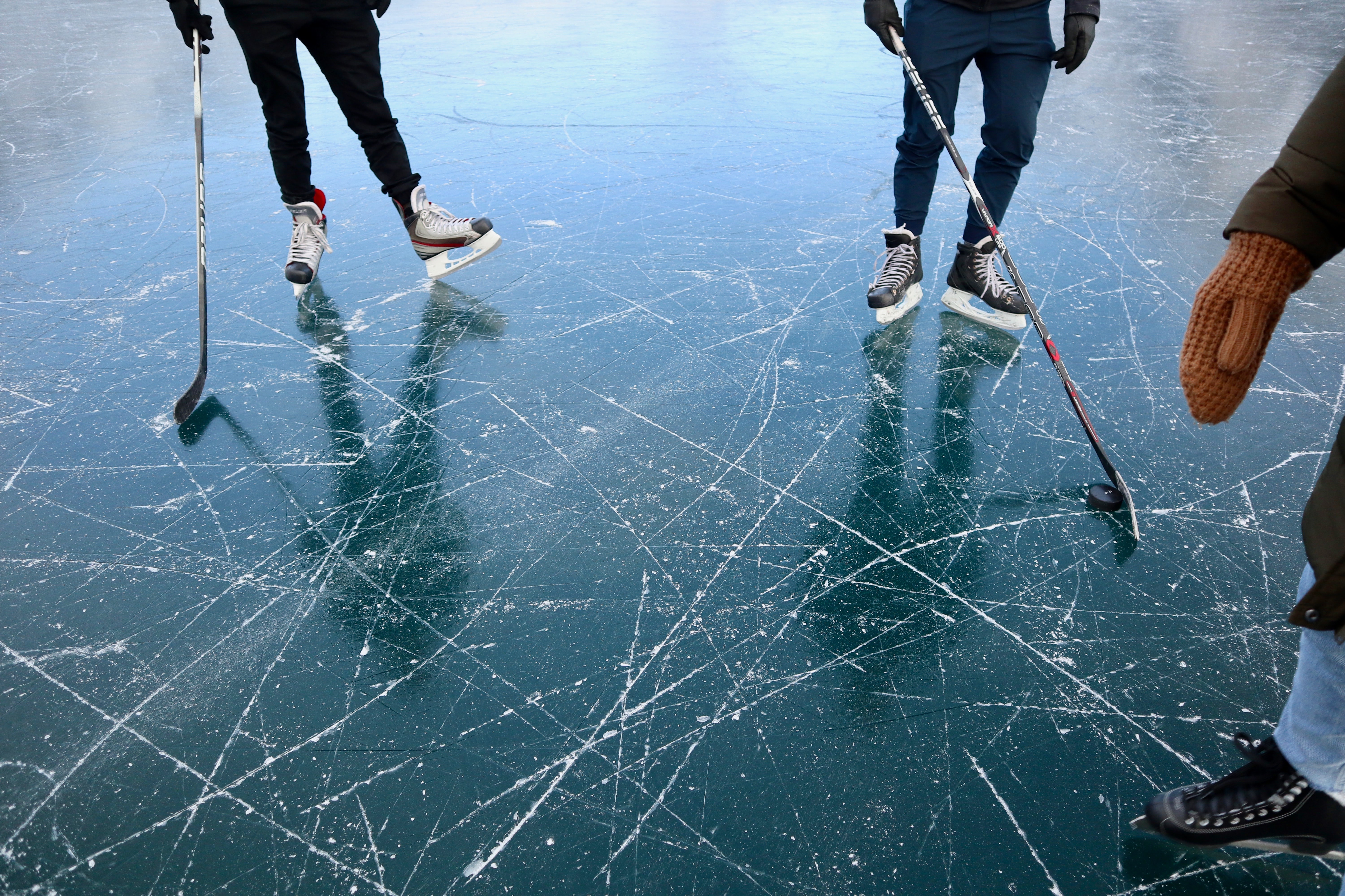three persons playing ice hockey